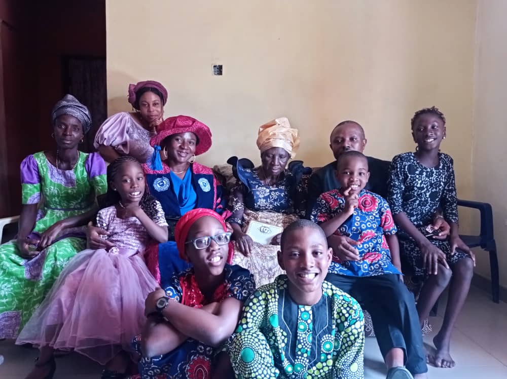 Josephine surrounded by family members in colourful clothing