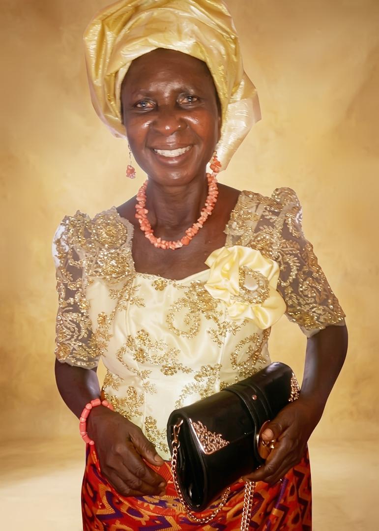 Josephine smiling in a patterned dress and headwrap
